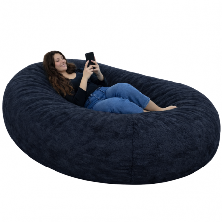 femme allongée sur un pouf long géant en fausse fourrure
